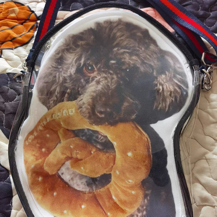 A crossbody bag printed with a poodle, under its clear shell